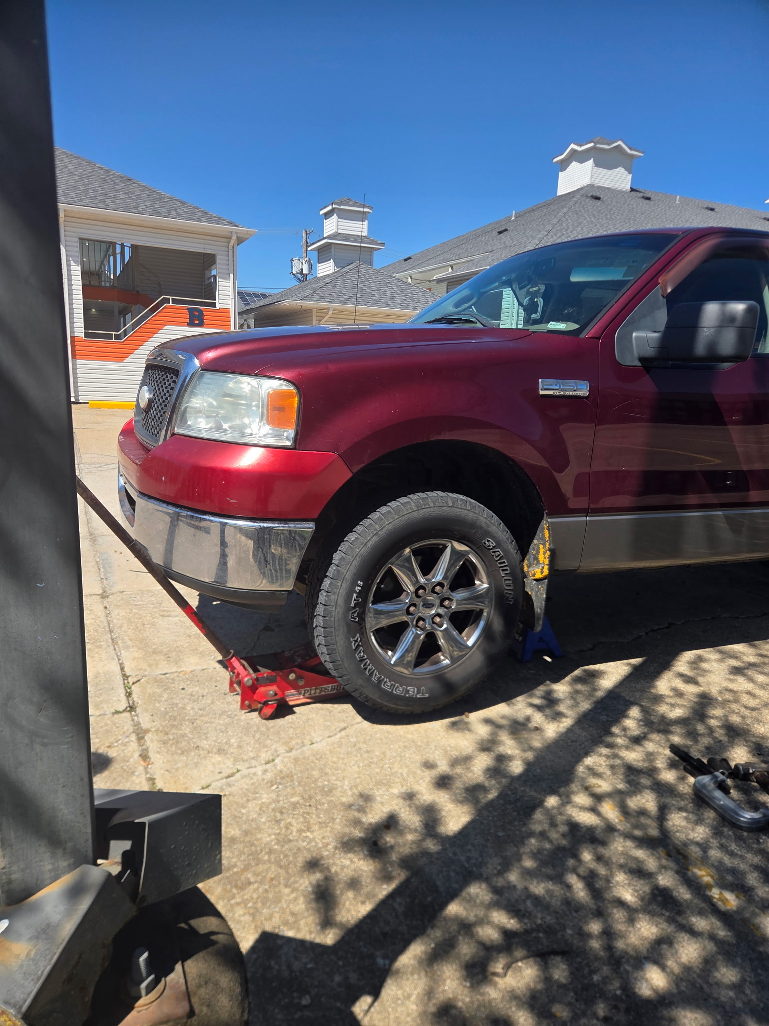 Ford F150 being serviced on a jack - mobile mechanic at work